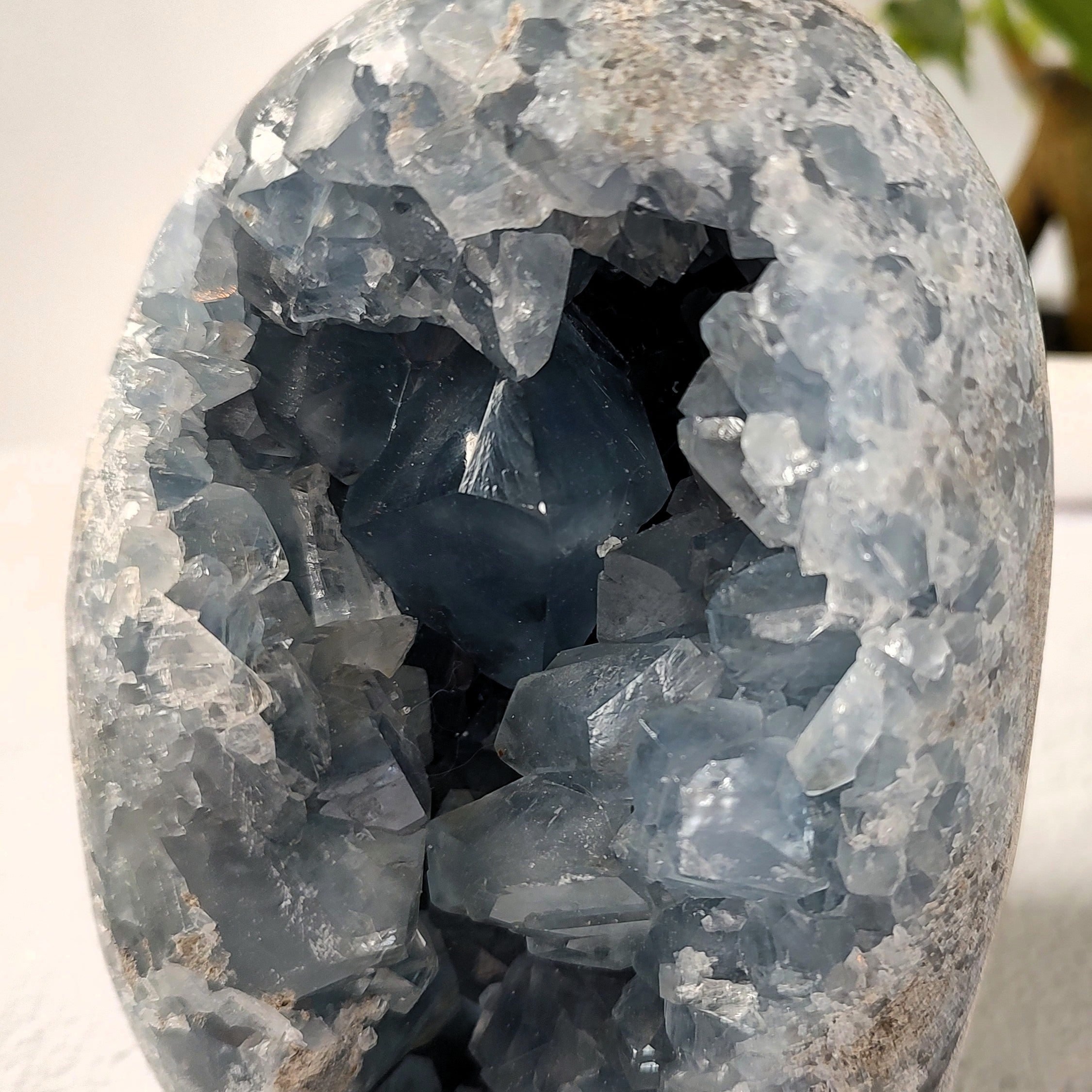 Closeup view of celestite geode crystals on a neutral background.