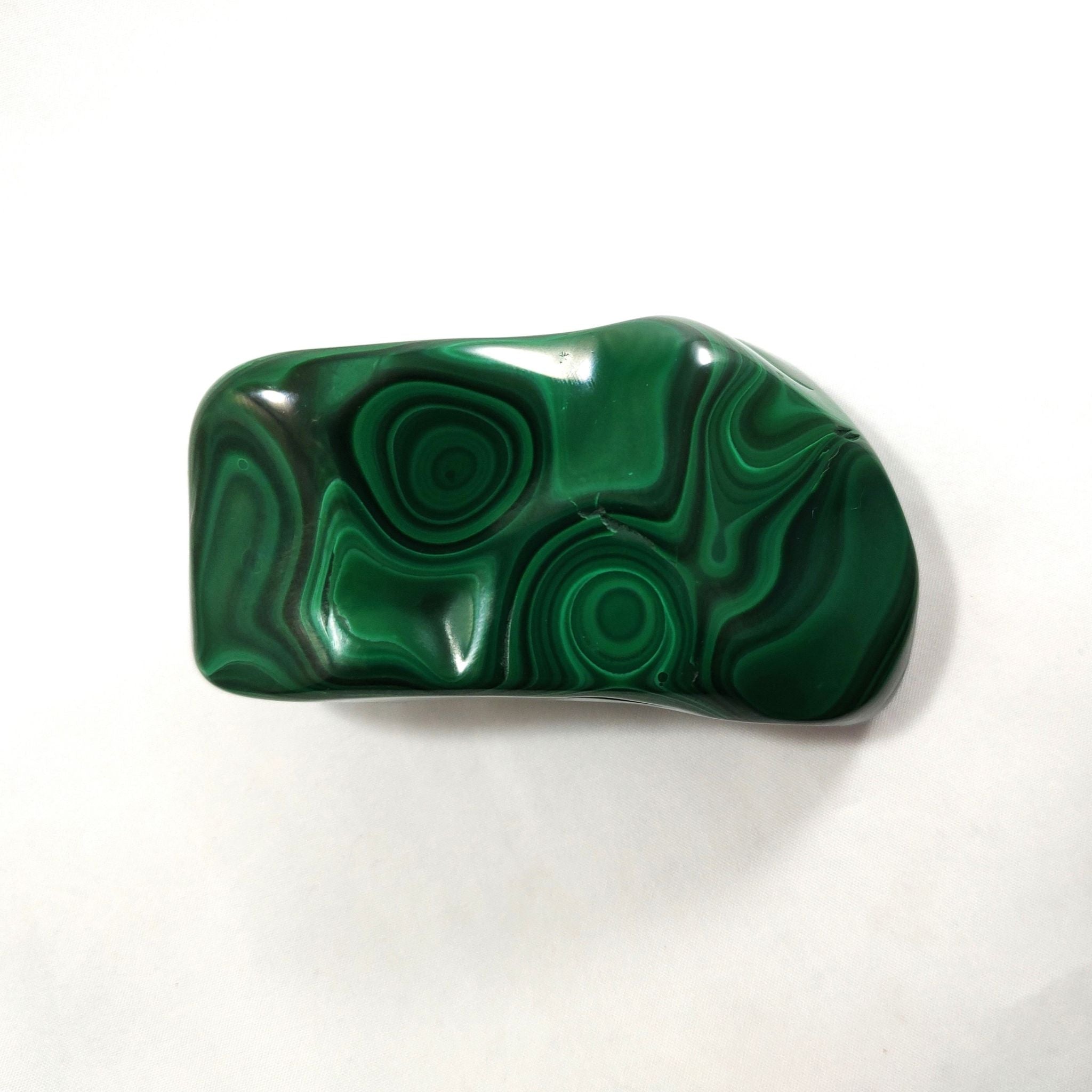 Malachite crystal freeform carving on a white background