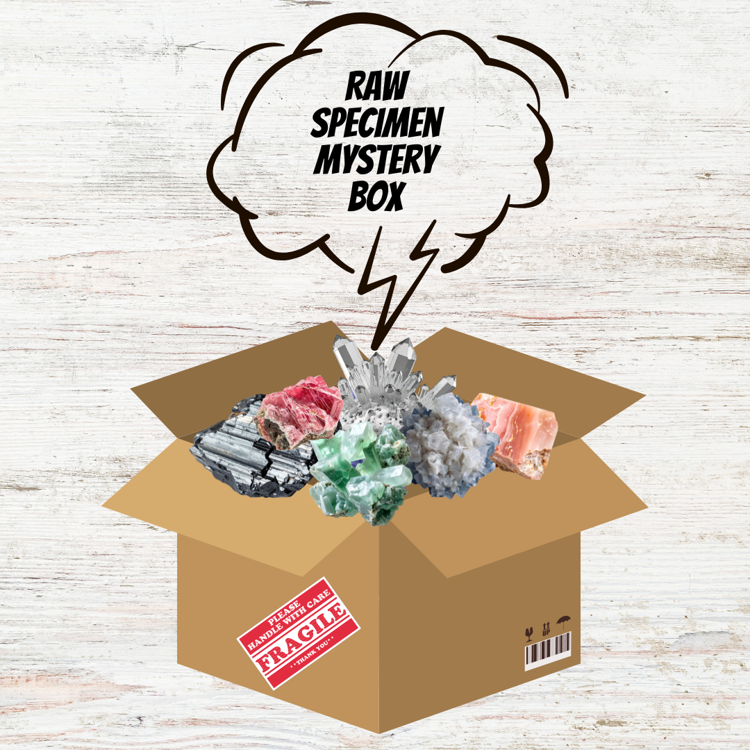 Open cardboard box with raw specimen mystery box contents on a wooden surface.