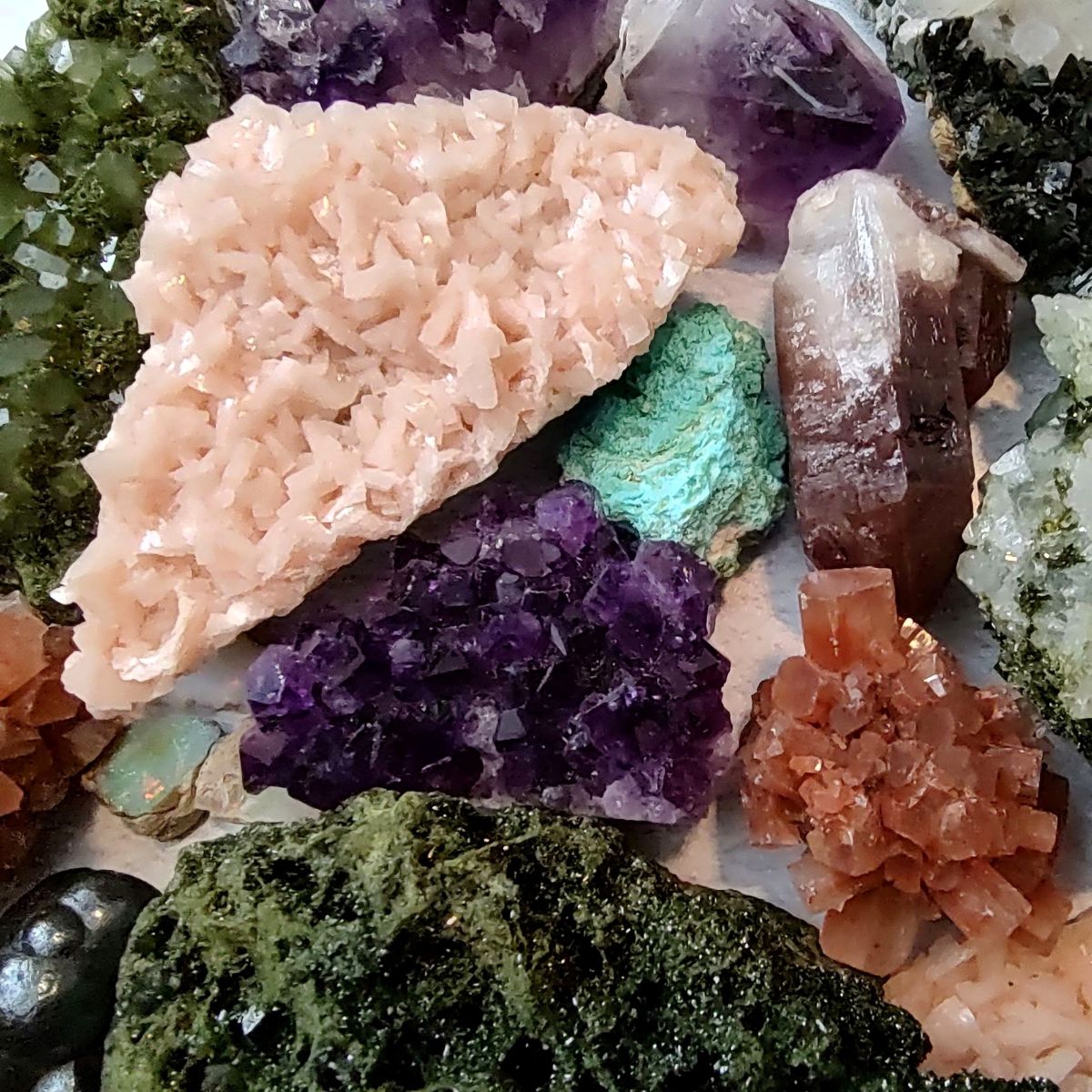 Group of raw crystal and mineral specimens on a white background. 